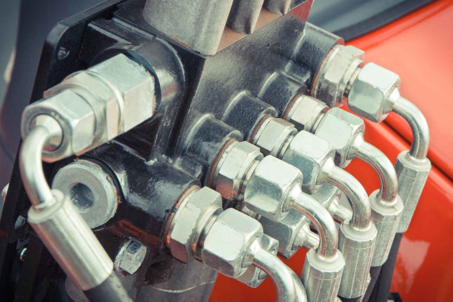 hydraulic hose fittings connected to industrial machinery with high-pressure pipes in a fluid power system.